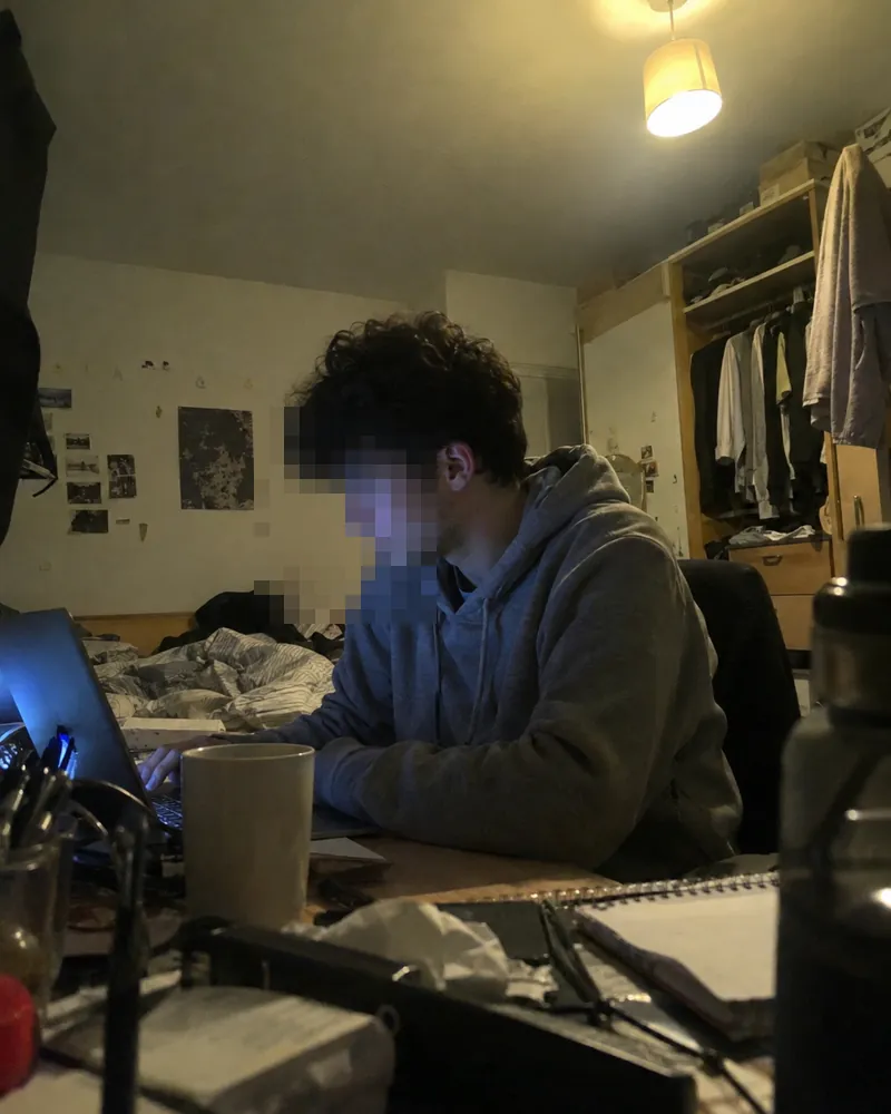 The maker of Lock In studying at night in his bedroom, face pixelated