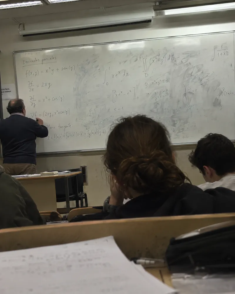 A calculus whiteboard covered in equations, seen from the back rows